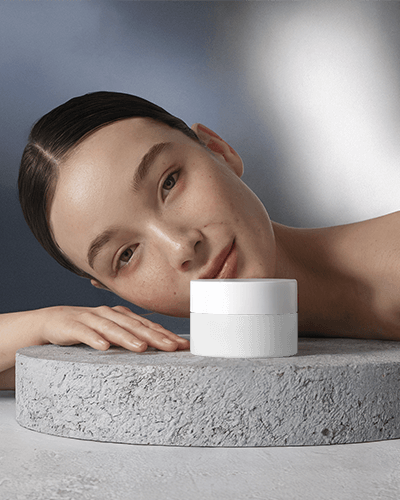 Soft Toned Cosmetic Mockup Glowing Female Model With Moisturizing Cream On Textured Pedestal
