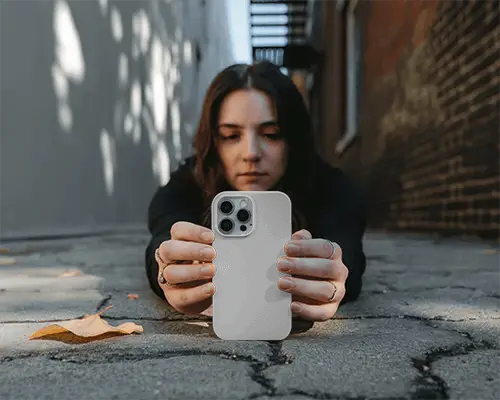 Urban Phone Case Mockup Female Model Holding Smartphone Cover On Street Ground Natural Outdoor Scene