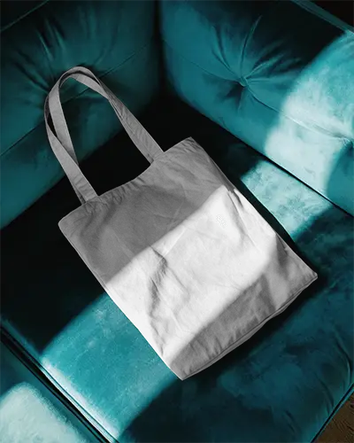 stylish-fabric-tote-bag-mockup-on-blue-velvet-couch-dramatic-light-shadow-modern-trendy-look