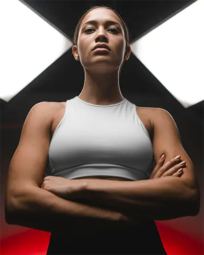 sporty-women-crop-top-mockup-showcasing-bold-stance-in-dramatic-fitness-setting