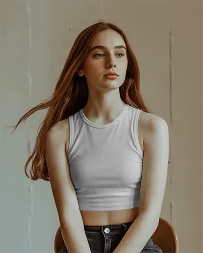 soft-light-crop-top-mockup-long-haired-model-sitting-on-chair-in-warm-minimal-studio