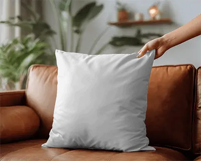 modern-square-cushion-mockup-on-leather-sofa-in-minimalist-living-room-setting-hand-placement