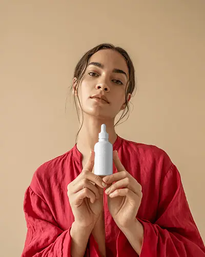 Minimalist Dropper Bottle Mockup Woman In Red Top Neutral Background Style
