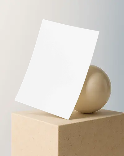 Beige Ball And Block A6 Flyer Mockup Leaning Against Ceramic Sphere Soft Daylight