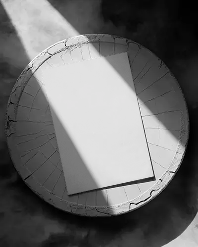 modern-flyer-mockup-on-textured-round-wooden-surface-with-dramatic-lighting-shadows