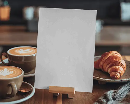 Cozy Cafe Flyer Mockup Tabletop Setup With Latte Art Croissant And Easel Warm Morning Ambience Perfect For Bakery Or Menu Designs 079