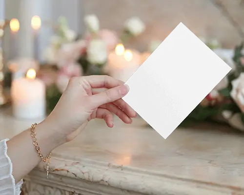 Romantic Candlelit Flyer Mockup Female Hand Holding Card Over Marble Surface With Soft Floral Background Warm And Elegant Wedding Vibe 086