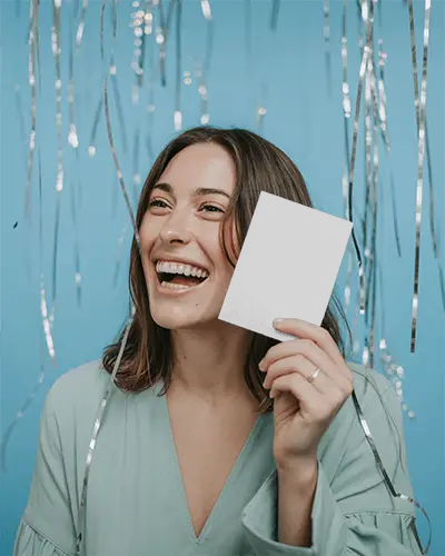 Happy Woman Holding New Year Greeting Card Mockup Celebration Hanging Decorations Background