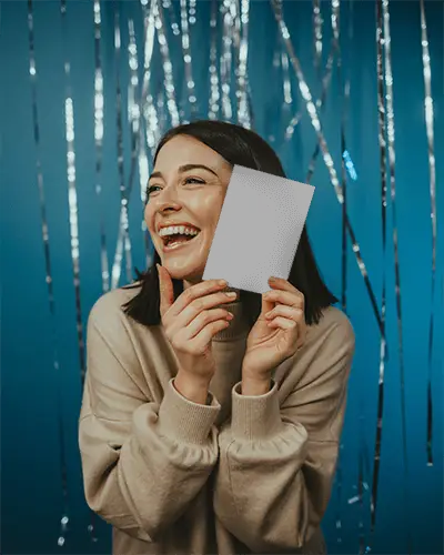 Joyful Woman Holding New Year Invitation Card Mockup With Shiny Party Background Celebration