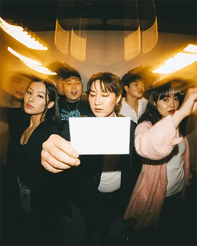 Group Of Friends Showing Empty Card Mockup For New Year Wishes And Party Invitation Ideas