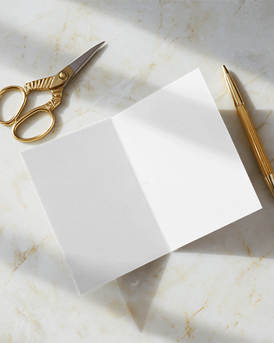 Open Greeting Card Mockup On Marble Surface With Golden Scissors And Pen Bright Natural Light Stationery Scene