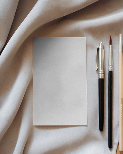 Artistic Greeting Card Mockup On Soft Fabric With Paintbrushes And Pen Flat Lay Creative Stationery Design Scene