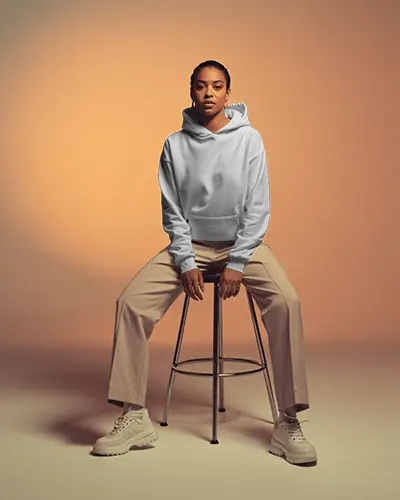 Warm Studio Hoodie Mockup Female Model Seated With Soft Shadow Lighting