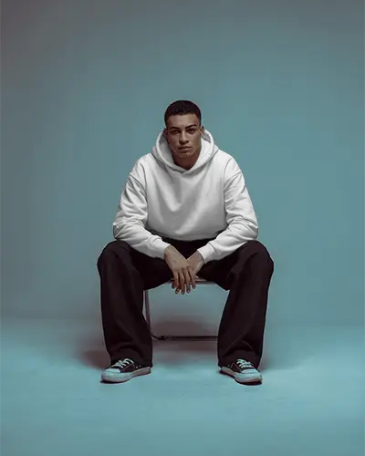 Comfortable Urban Hoodie Mockup For Men Sitting Dynamic Casual Wear In Studio Setting