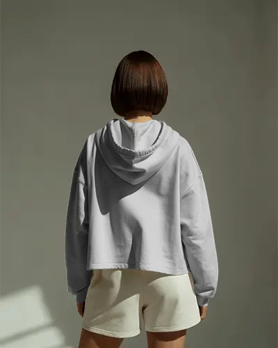 Backview Hoodie Mockup Female Model In Sunlit Studio Soft Shadow On Neutral Wall Surface