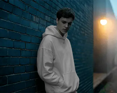 Moody Alley Hoodie Mockup Male Model Against Brick Wall Under Streetlight Night Scene