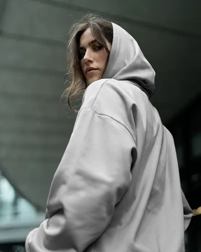 Urban Street Hoodie Mockup Female Model Looking Over Shoulder Modern Architectural Setting