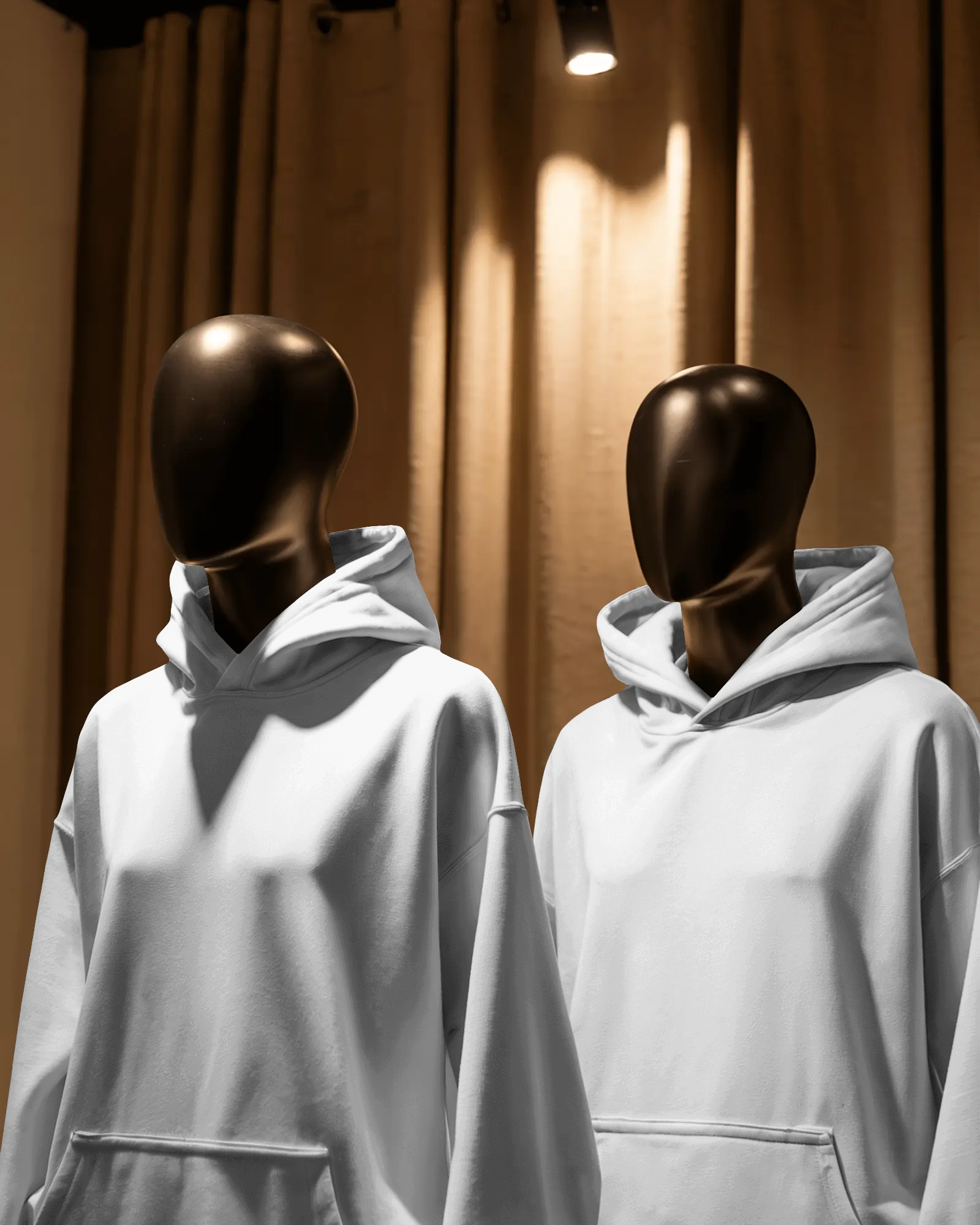 Boutique Display Hoodie Mockup Two Mannequins Under Spotlight Warm Toned Curtain Backdrop
