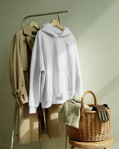 Cozy Home Hoodie Mockup Hanging Beside Trench Coat With Wicker Basket