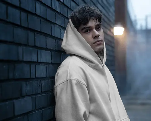 Moody Streetwear Hoodie Mockup Male Model Leaning On Dark Brick Wall Evening Scene