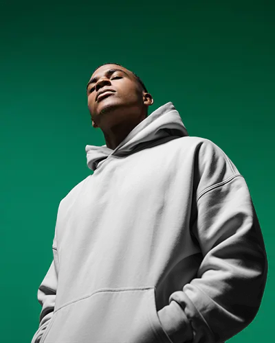 Bold Green Background Hoodie Mockup Male Model Upward Angle Power Pose