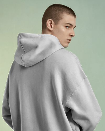 Moody Urban Hoodie Mockup Female Model In Oversized Hoodie With Hood Up Gritty Cityscape Background Modern And Edgy Streetwear