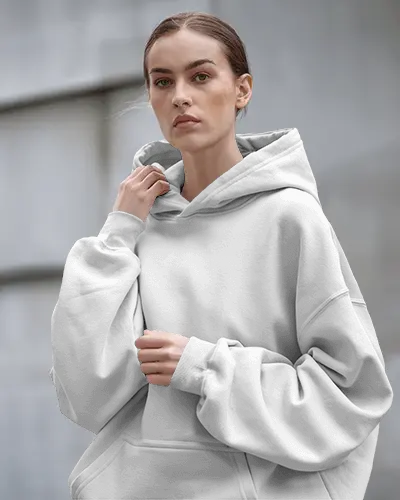 Streetwear Hoodie Mockup Featuring Confident Woman In Relaxed White Hoodie Against Architectural Backdrop