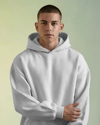 Minimalist Hoodie Mockup On Male Model Standing Confidently In Bright Soft Light And Colored Backdrop