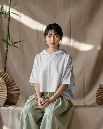 Natural Light Hoodie Mockup Female Model Sitting Peacefully In Zen Inspired Setting