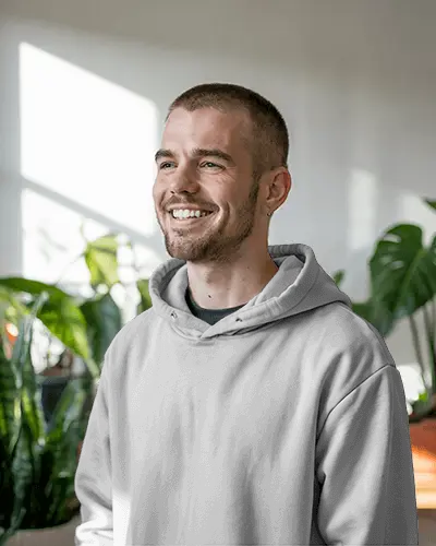 Natural Light Hoodie Mockup Happy Man Wearing Minimal Hoodie In Cozy Modern Room