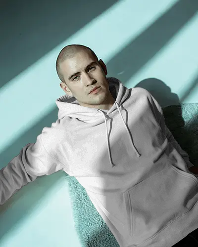 Fashion Forward Flatlay Hoodie Mockup Male Model Relaxing In Soft Lit Studio Setting