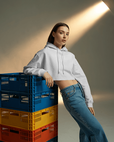 Cropped Hoodie Mockup Female Model Leaning On Colorful Crates Under Soft Spotlight
