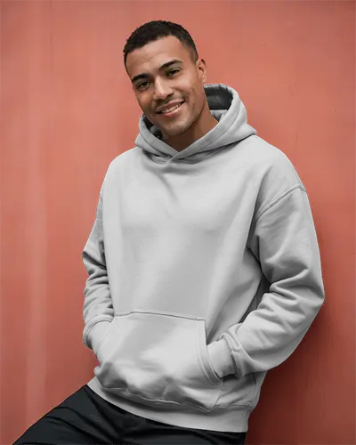 Cheerful Outdoor Hoodie Mockup Male Model Smiling Casually Against Warm Coral Wall In Natural Light 0599