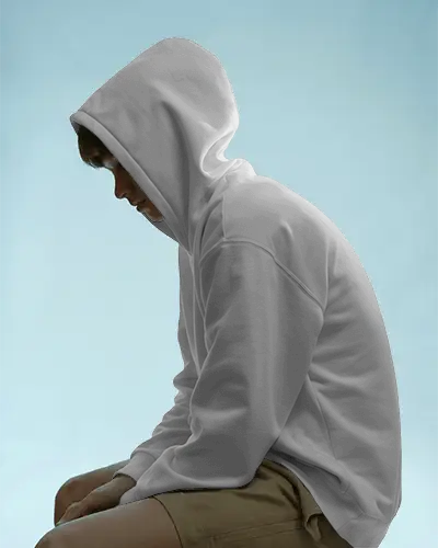 Moody Seated Hoodie Mockup With Hooded Male Model Against Soft Blue Backdrop Perfect For Streetwear Branding
