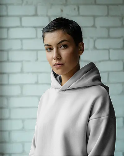 Moody Brick Wall Hoodie Mockup Female Model With Short Hair Soft Lighting And Neutral Tones