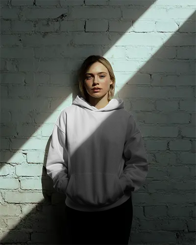 Dramatic Light Hoodie Mockup Female Model Against White Brick Wall With Shadow