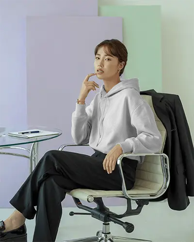 Pastel Background Hoodie Mockup Female Model Sitting On Office Chair In Modern Minimalist Studio  0798