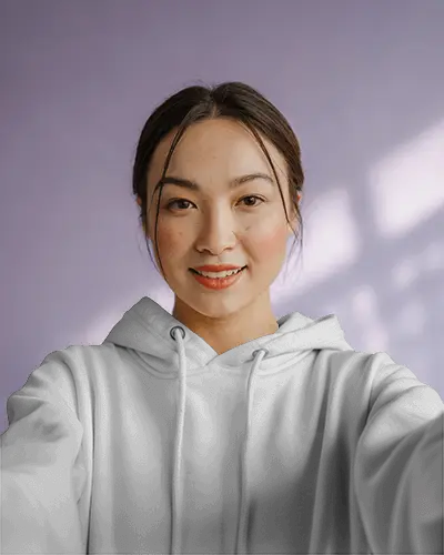 Smiling Female Hoodie Mockup Front View In Soft Daylight With Light Purple Wall Background
