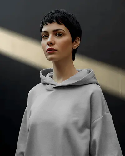 Minimal Street Hoodie Mockup Short Haired Female Model In Soft Sunbeam Light Against Dark Wall