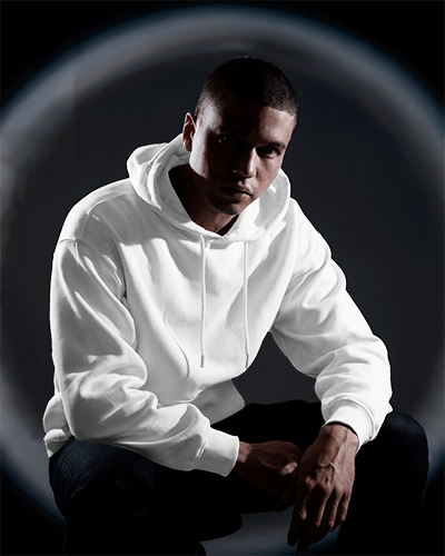 Full Body Pose Showcasing Confidence With Hands In Pockets Highlighting The Sleek Silhouette Of The Hoodie Mockup Against A Shadowy Backdrop