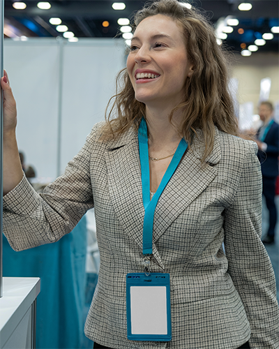 id-card-mockup-smiling-woman-in-checkered-blazer-wearing-blue-lanyard-trade-show-networking-ambience-061