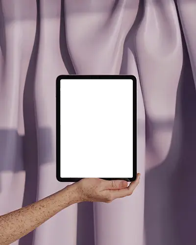 Ipad Mini Mockup Hand Holding Device In Front Of Flowing Satin Curtain Background