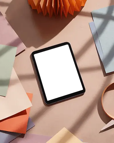 Ipad Air Mockup Top View On Pastel Desk With Colorful Paper Sheets And Soft Sunlight