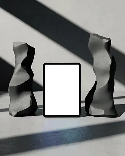 Ipad Air Mockup Centered Between Abstract Stone Sculptures With Dramatic Shadow Light Interplay