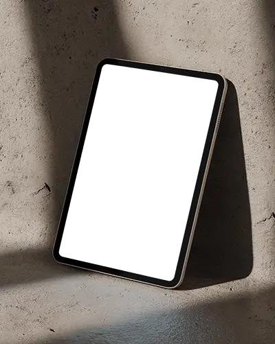 Ipad Mini Mockup Leaning Against Concrete Wall With Soft Directional Lighting And Neutral Tones