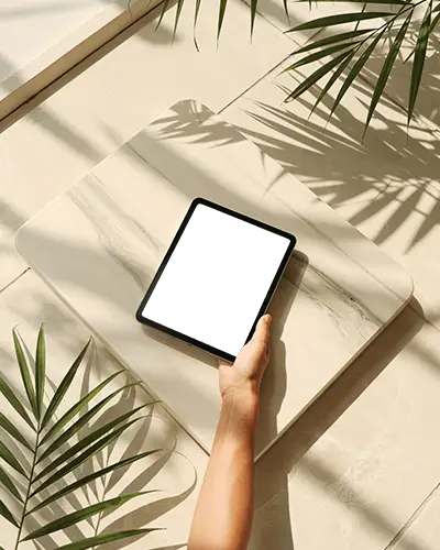 ipad-mini-mockup-on-marble-platform-with-hand-holding-and-sunlit-tropical-leaf-shadows