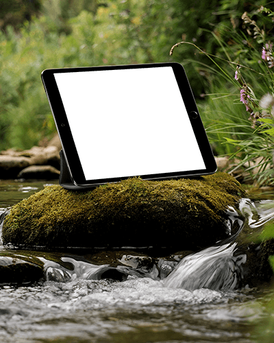 Adventurous Ipad Mockup Digital Device On Wet Stone Amidst Flowing Water And Vibrant Forest Backdrop