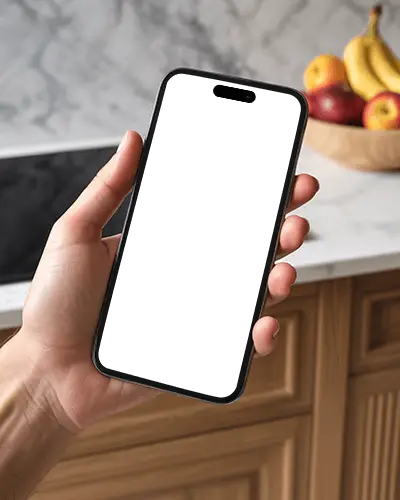 Iphone 16 Mockup Handheld In Kitchen Scene With Fruit Bowl And Marble Counter Background