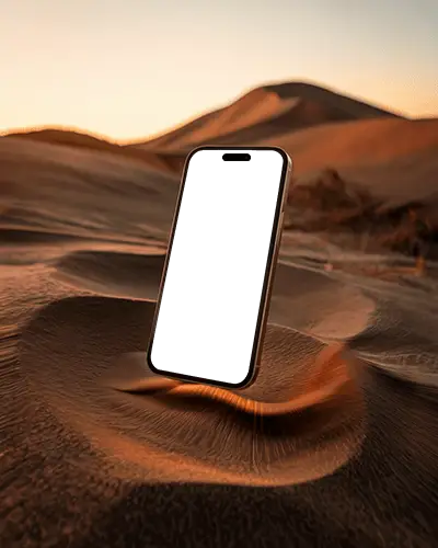 Iphone 15 Plus Mockup Angled Above Sand At Sunset With Soft Golden Hour Lighting