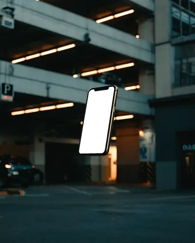 Floating Iphone 12 Mockup In Dark Parking Lot With Warm Lights And Urban Street Mood